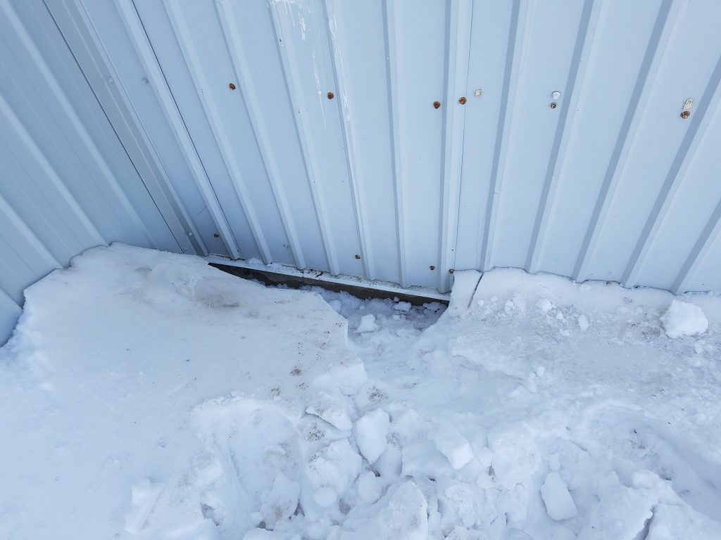 Hole under the snow drift where kitten was stuck